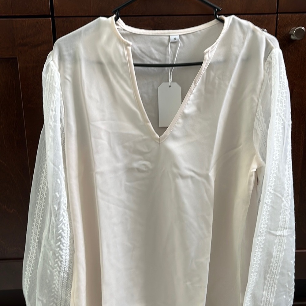Beige top with white embroidered sleeves, size small never worn.